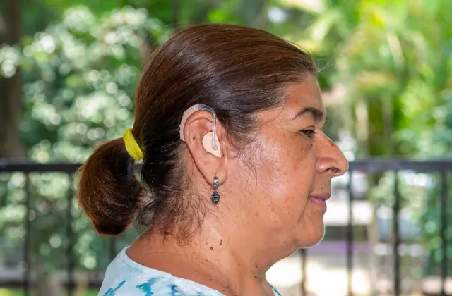 Mujer utilizando auxiliar auditivo